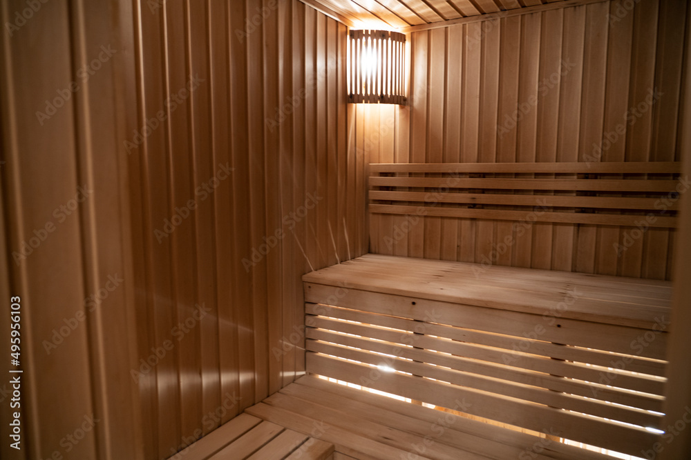 Seat in sauna room. Empty wooden steam room with stone heater.Sauna room for good health. Sauna room with traditional sauna accessories.Healthy and spa life style. High quality photo Seat in sauna room. Empty wooden steam room with stone heater.Sauna room for good health. Sauna room with traditional sauna accessories.Healthy and spa life style. High quality photo