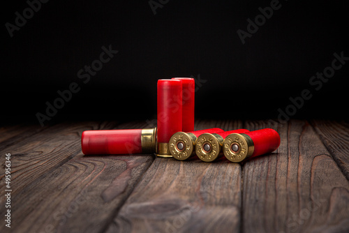 Shotgun cartridges on a brown wooden table. Ammunition for 12 gauge smoothbore weapons. Hunting ammunition.