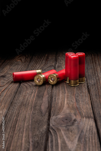 Shotgun cartridges on a brown wooden table. Ammunition for 12 gauge smoothbore weapons. Hunting ammunition.