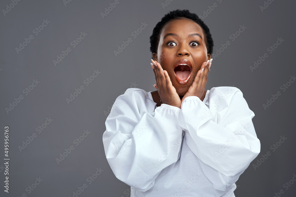 You dont want to miss out. Shot of a young woman looking surprised while posing against a grey background. You dont want to miss out. Shot of a young woman looking surprised while posing against a grey background.