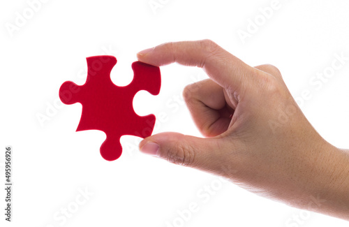 Hand holding a puzzle piece on white background