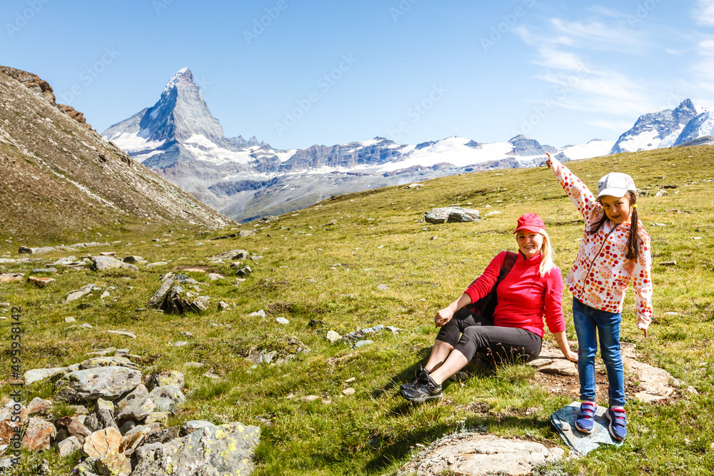 Happy hiker woman and girl at mountains lake