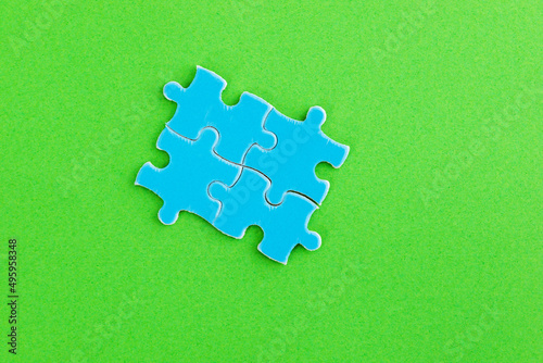 Four blue puzzle pieces on green background