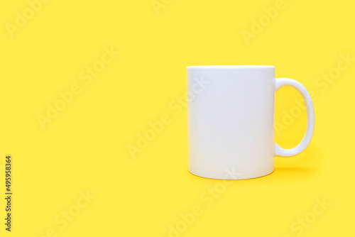 White mug on a yellow background with free space for text. White cup with a drink on an empty yellow background. Cafe or snack concept. White mug with the possibility of applying advertising or logo