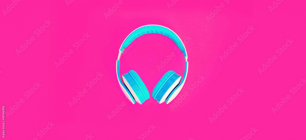 Close up of headphones on colorful pink background, top view Close up of headphones on colorful pink background, top view
