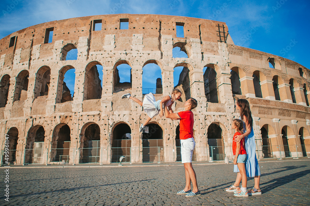 Happy family in Europe. Parents and kids in Rome over Coliseum background