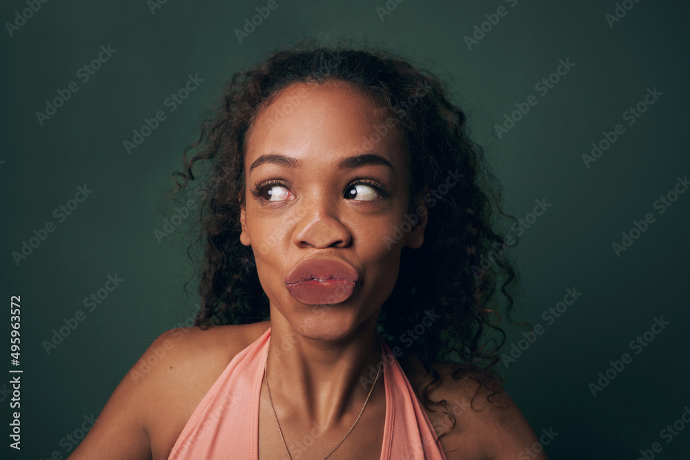 Kissing the camera. Cropped shot of an attractive and quirky young woman posing against a green background in studio. Kissing the camera. Cropped shot of an attractive and quirky young woman posing against a green background in studio.