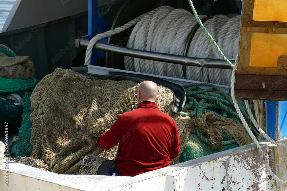 Pescatore sul peschereccio mentre prepara la rete da pesca
