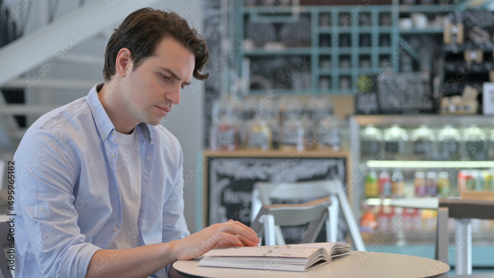 Creative Man Reading Book in Cafe 