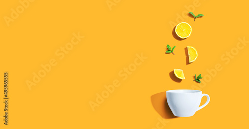 Fresh yellow lemons with tea cup overhead view - flat lay