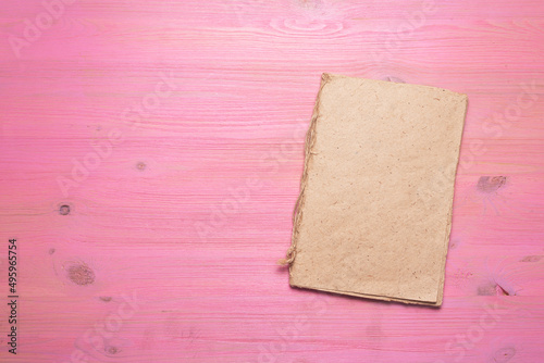 Blank page book with copy space on the pink wooden flat lay background.