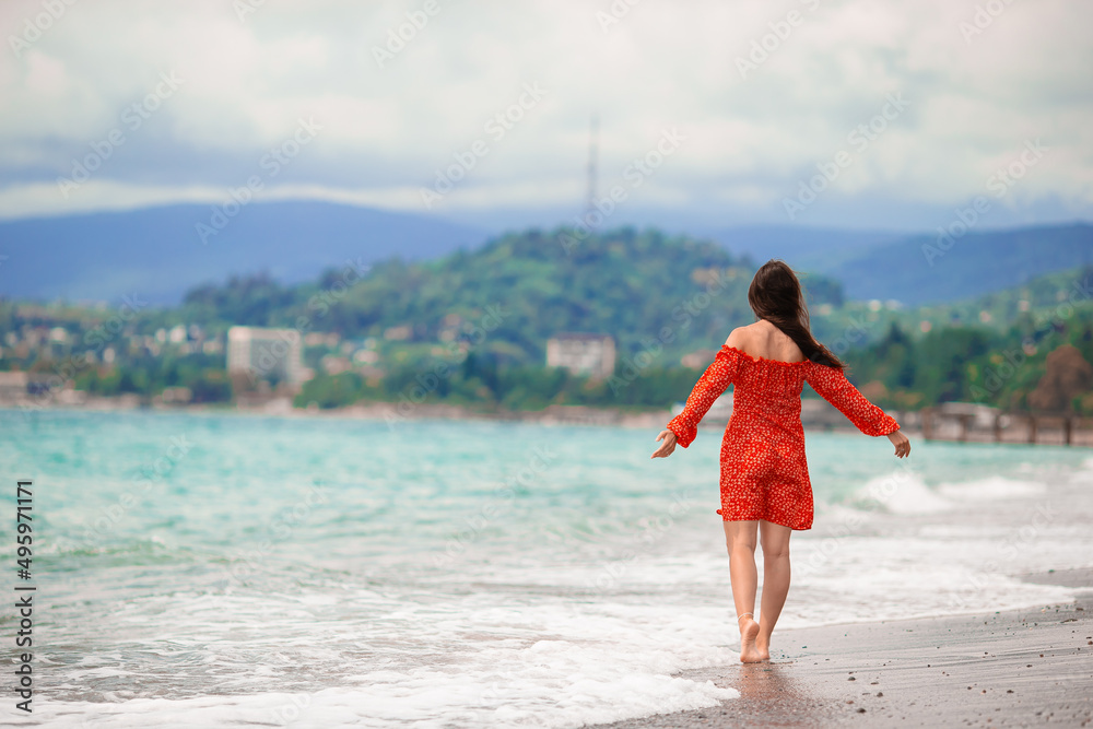 Happy girl background the blue sky and turquoise water in the sea on caribbean island Happy girl background the blue sky and turquoise water in the sea on caribbean island