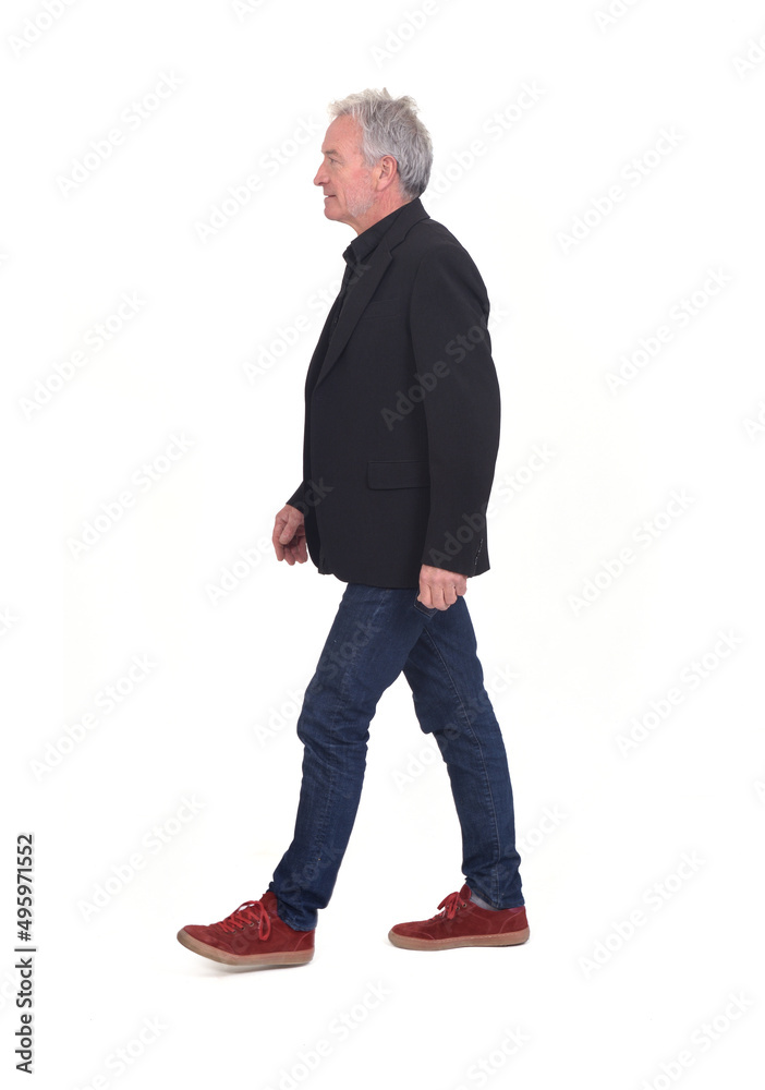 Naklejka premium side view of senior man walking on white background