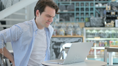 Creative Man with Laptop having Back Pain 