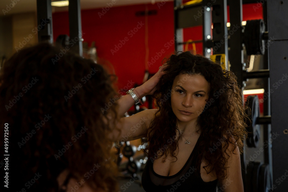 Fototapeta premium Hot steamy gym session with curly brunette toned female model