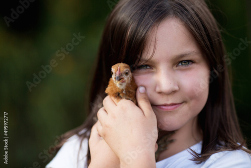 dzieci i zwierzęta - dziewczynka przytula z miłością swoją kurkę