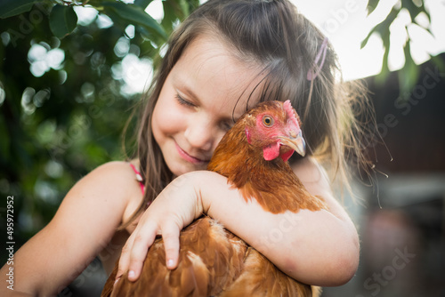 dzieci i zwierzęta - dziewczynka przytula z miłością swoją kurkę