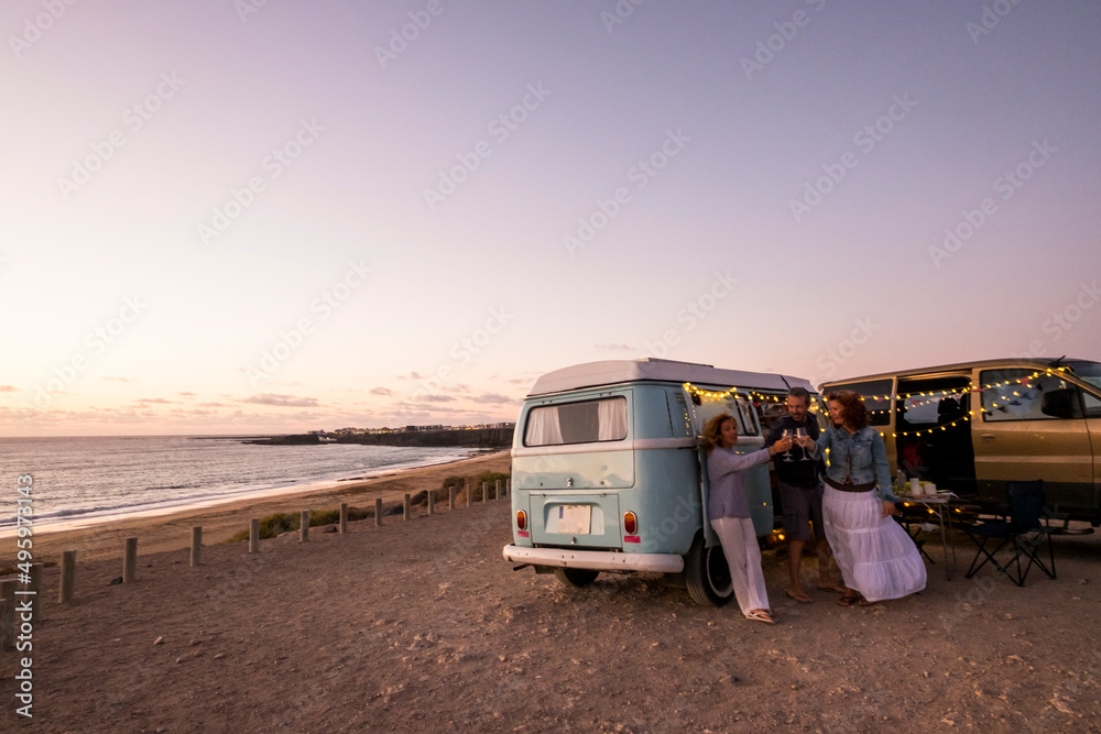 Group of friends celebrate toasting in summer travel holiday vacation. Camper van lifestyle. people man and women together having fun in outdoor leisure activity. Ocean view in free camp site