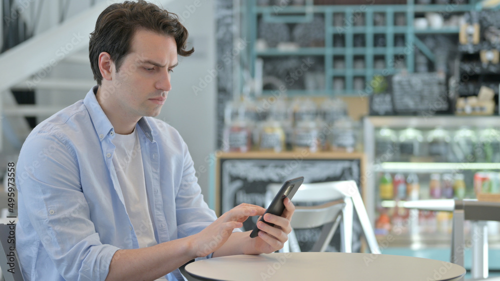 Attractive Creative Man using Smartphone in Cafe Attractive Creative Man using Smartphone in Cafe