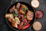 Grilled meat platter in a pan and sauces