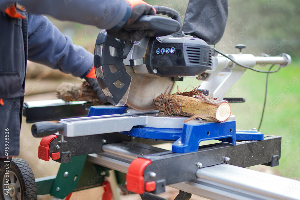 Contractor worker using big circular saw to cut branches for fire wood Contractor worker using big circular saw to cut branches for fire wood