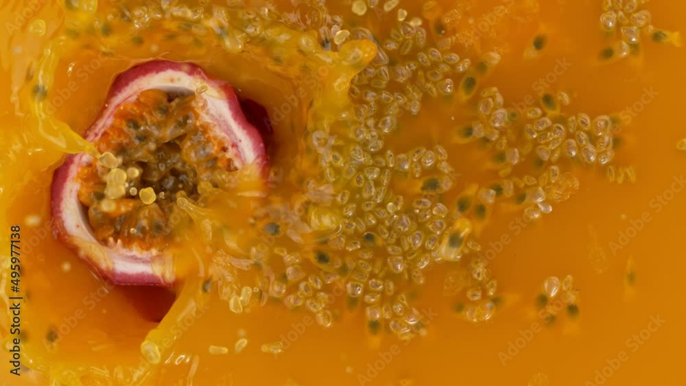 Fresh sliced passion fruit falling into juice, super slow motion filmed on high speed cinematic camera at 1000 fps.