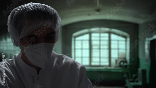 Scary caucasian doctor puts on medical gloves in an abandoned asylum. Close-up in dark old hospital. High quality 4k footage