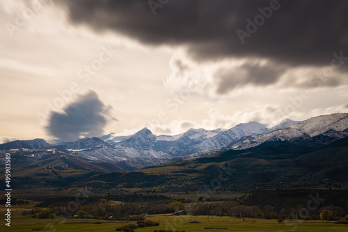 2022-03-29 SNOW COVERED ABSAROKA MOUNTATIN RANGE AND VALLEY NEAR PRAY MONTANS WITH BLURRY FAST MOVING STORM CLOUDS photo