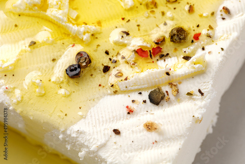 Feta greek cheese, Natural homemade marinated cheese close up with olive oil and pepper. Top view, textured