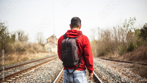 young photographer walking along train track