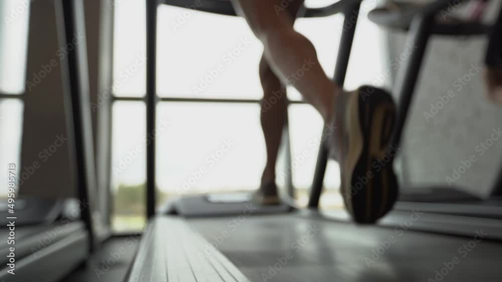 Close-up of the legs of the girl running on the treadmill