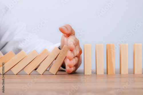 hand controlling domino effect pollution, business concept photo
