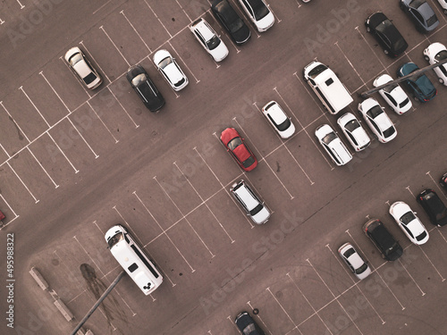 Parking lot with many parked cars at business center or mall, aerial view. City transportation concept