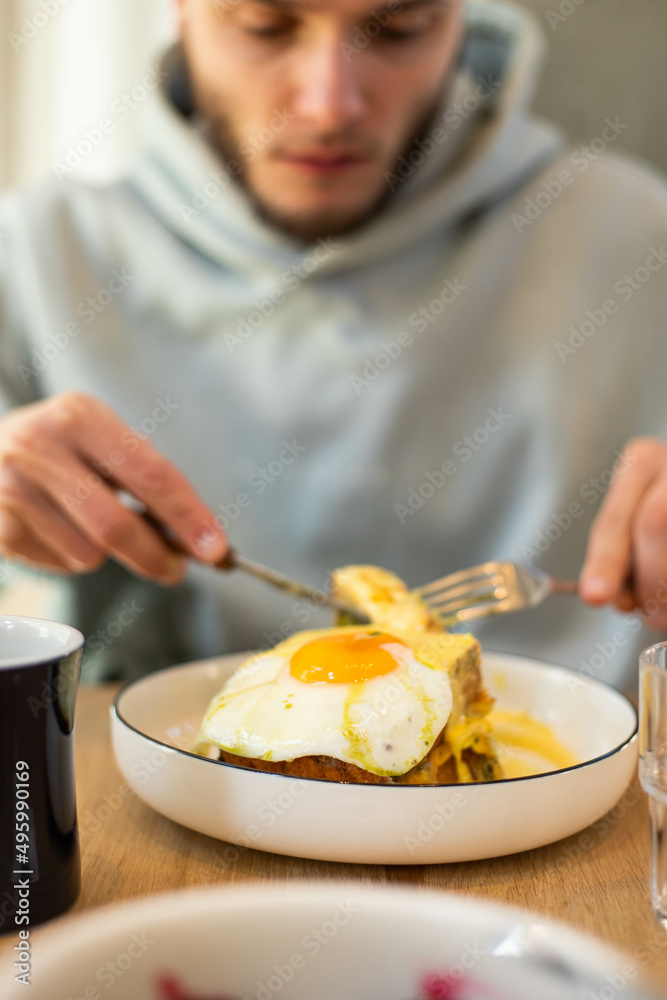young man eating a sandwich for breakfast young man eating a sandwich for breakfast