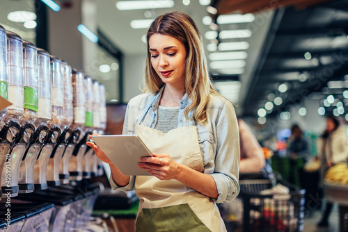 Employee in supermarket checking product