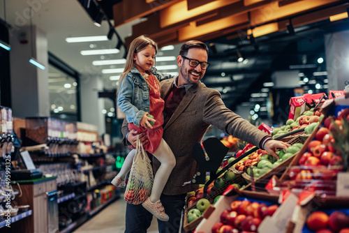 Papier peint Father and daughter buying apples in grocery store