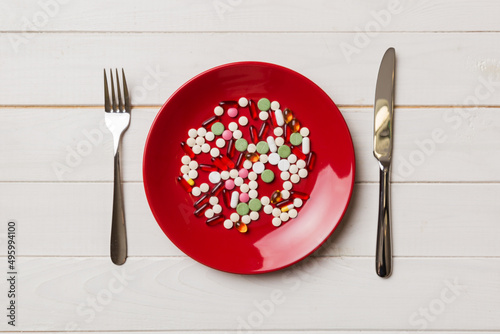 Many different weight loss pills and supplements as food on round plate. Pills served as a healthy meal. Drugs, pharmacy, medicine or medical healthycare concept photo