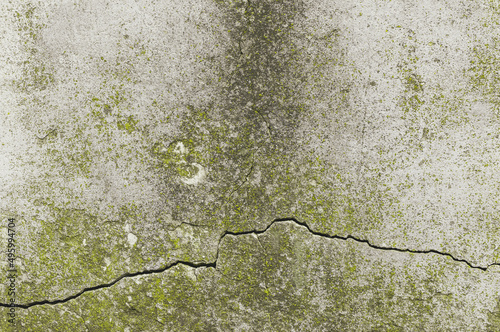 Postarzana stara pionowa uliczna ściana z teksturą pęknięć. Naturalne tło, tapeta.