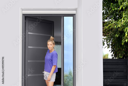 Beautiful woman opening the door of her home.