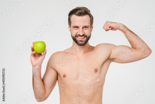 Strong caucasian young topless shirtless man with muscles holding green apple, taking care of his body, training, dieting, healthy eating concept isolated in white background