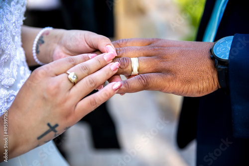 Bride putting ring on grooms`s finger closeup of hands and ring
