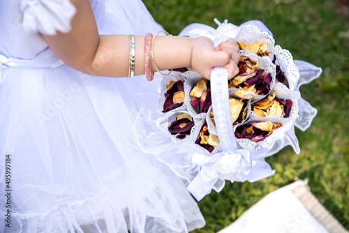 Rose Petal confetti in white basket in the hand of small flower girl