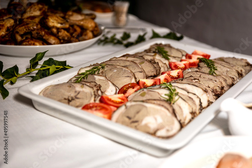 Roasted meat cold cut slices on a white platter