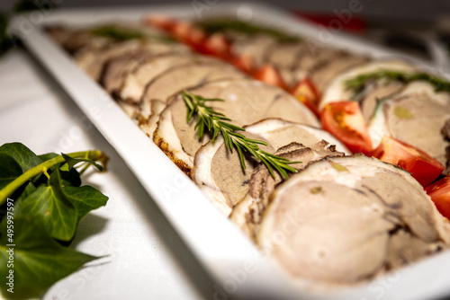 Roasted meat cold cut slices on a white platter