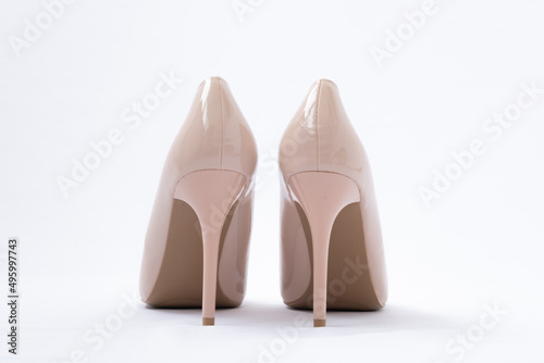 Elegant beige women's shoes with high heels. White background. Polished leather. back view