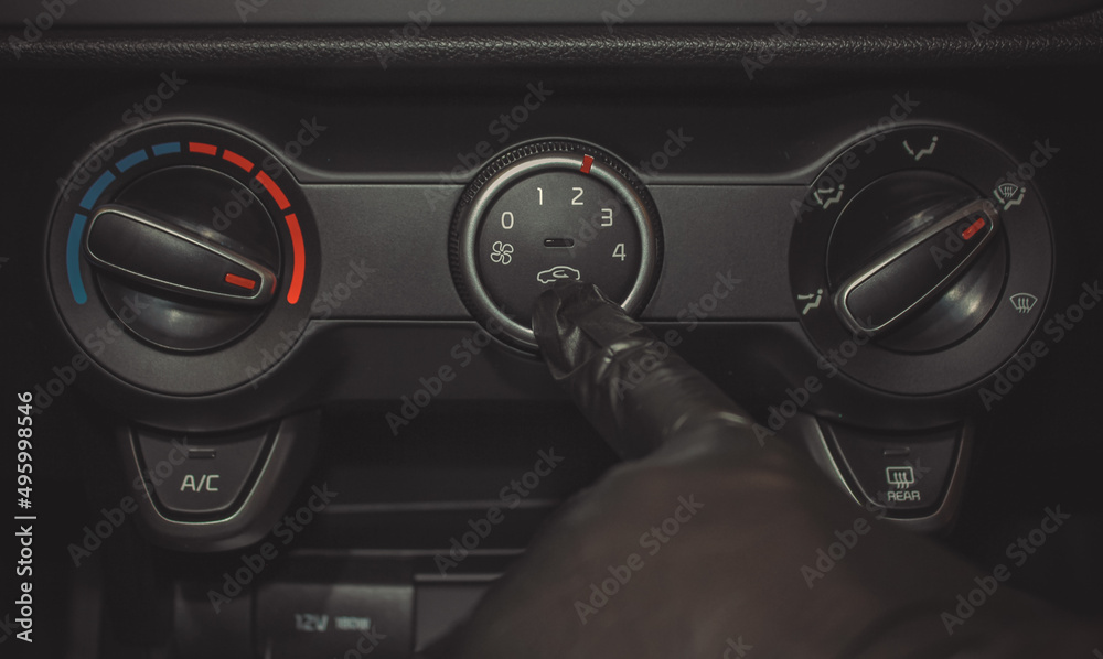 A man in rubber gloves turns on the air conditioner in the car. The driver turns on the car's climate control system. travel by car. Close-up view with selective focus.