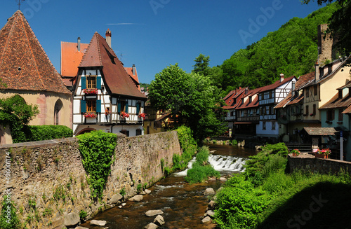 Beautiful Timbered Houses At The Weissbach Creek In Kaysersberg Alsace France On A Beautiful Sunny Spring Day With A Clear Blue Sky photo