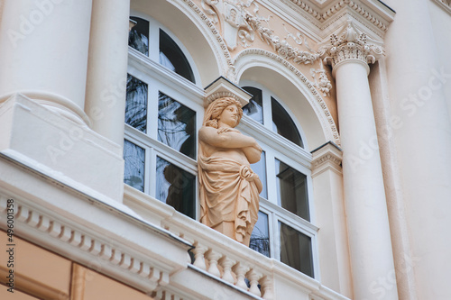 Antique window in neoclassical style with columns, capitals and a caryatid in the form of a Greek woman. Lviv University named after Ivan Franko. Ukraine. photo