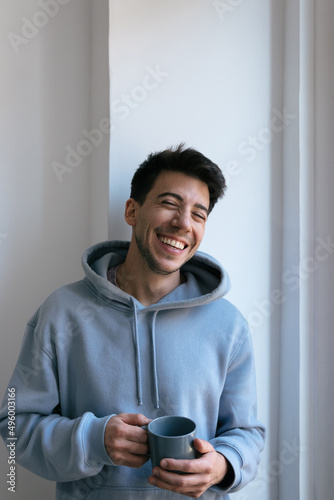 Attractive man holding a mug at home
