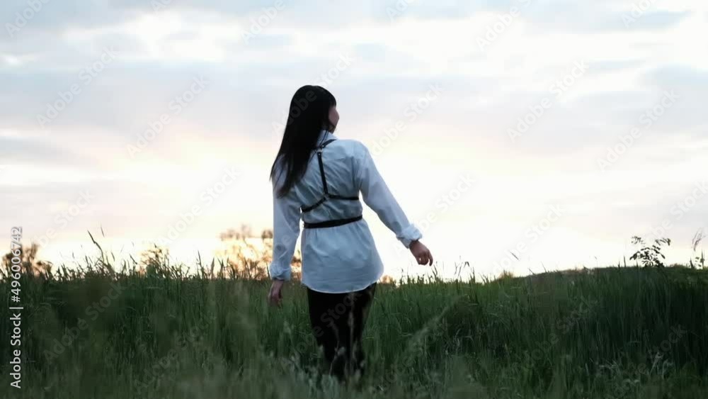 brunette woman in white blouse with baldric on summer field on sunset. peaceful time. millennial generation. calm female. brunette woman in white blouse with baldric on summer field on sunset. peaceful time. millennial generation. calm female.